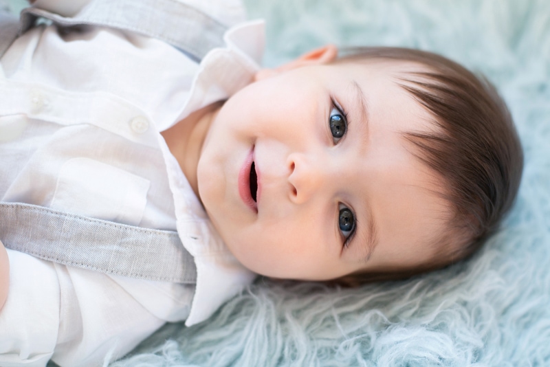 milestone photography, a baby boy lays on a fluffy carpet