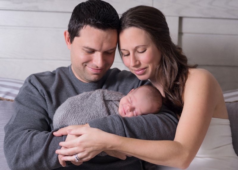 Newborn Photography, young father and mother hold their new baby