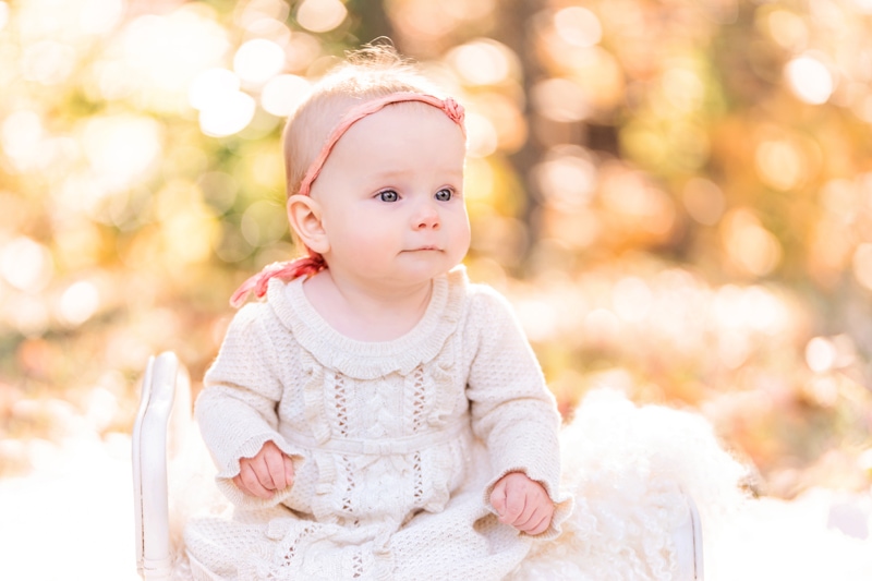 milestone photography, baby girl wears a knit dress and happily gazes outside