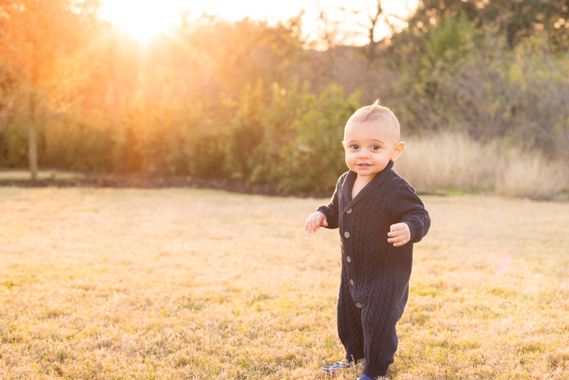 milestone photography, a baby boy walks through the yard at golden hour