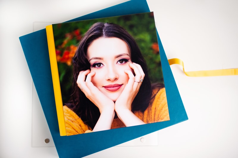 High School Senior Photography, a print of an image containing a high school woman lays atop an album