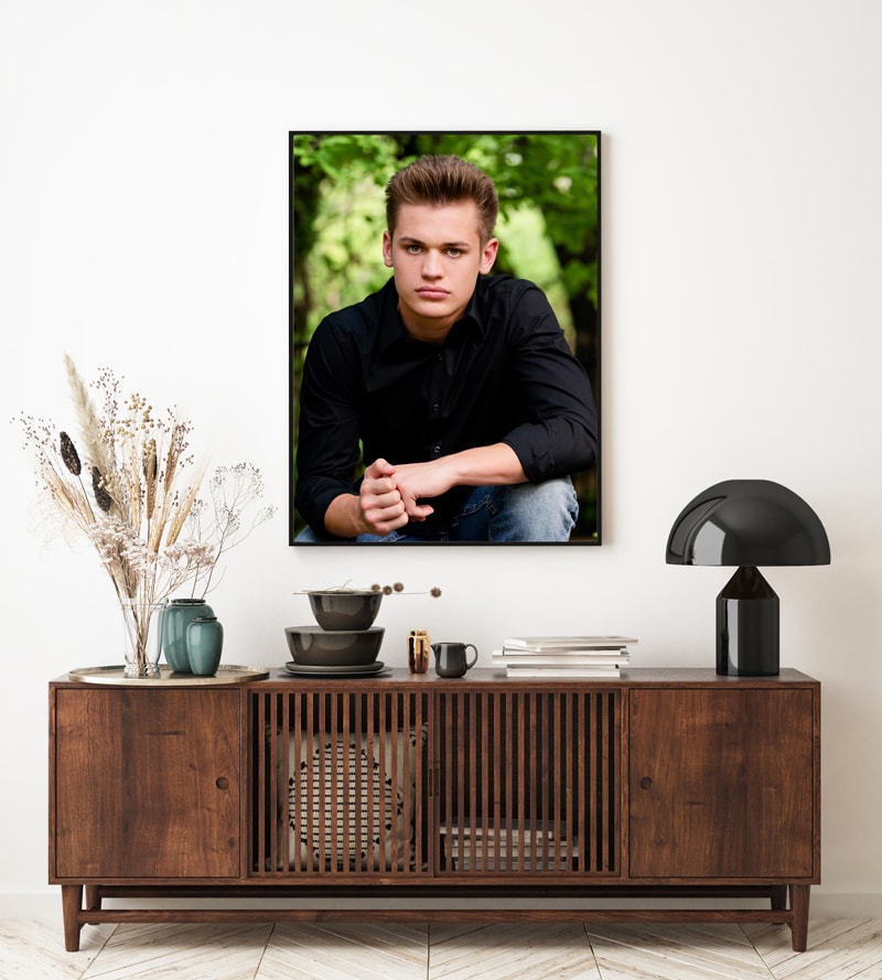 Senior Photography, A poster print image is hung atop a living room hutch, it contains a portrait of a young high school man