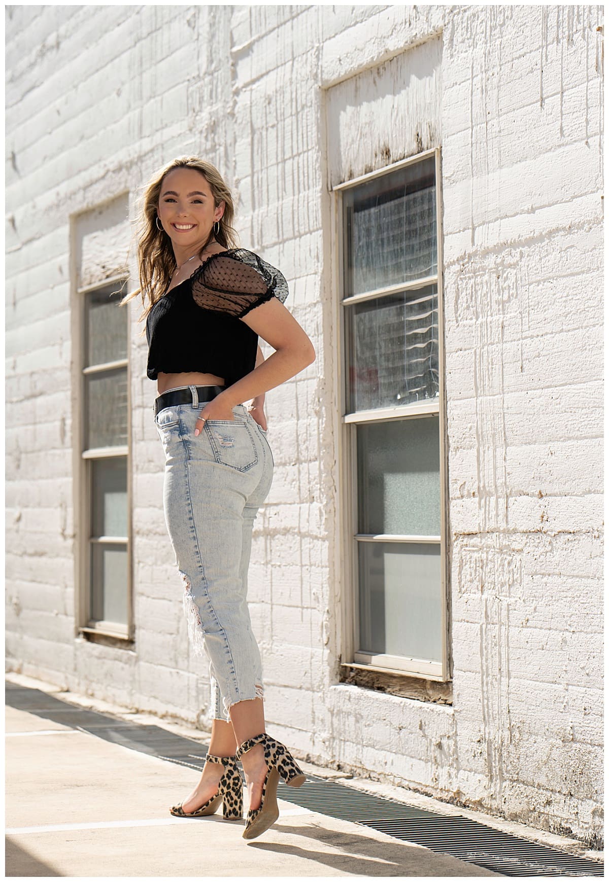 girl stands in front of white brick wall for Downtown Georgetown + Spring Wildflower Session