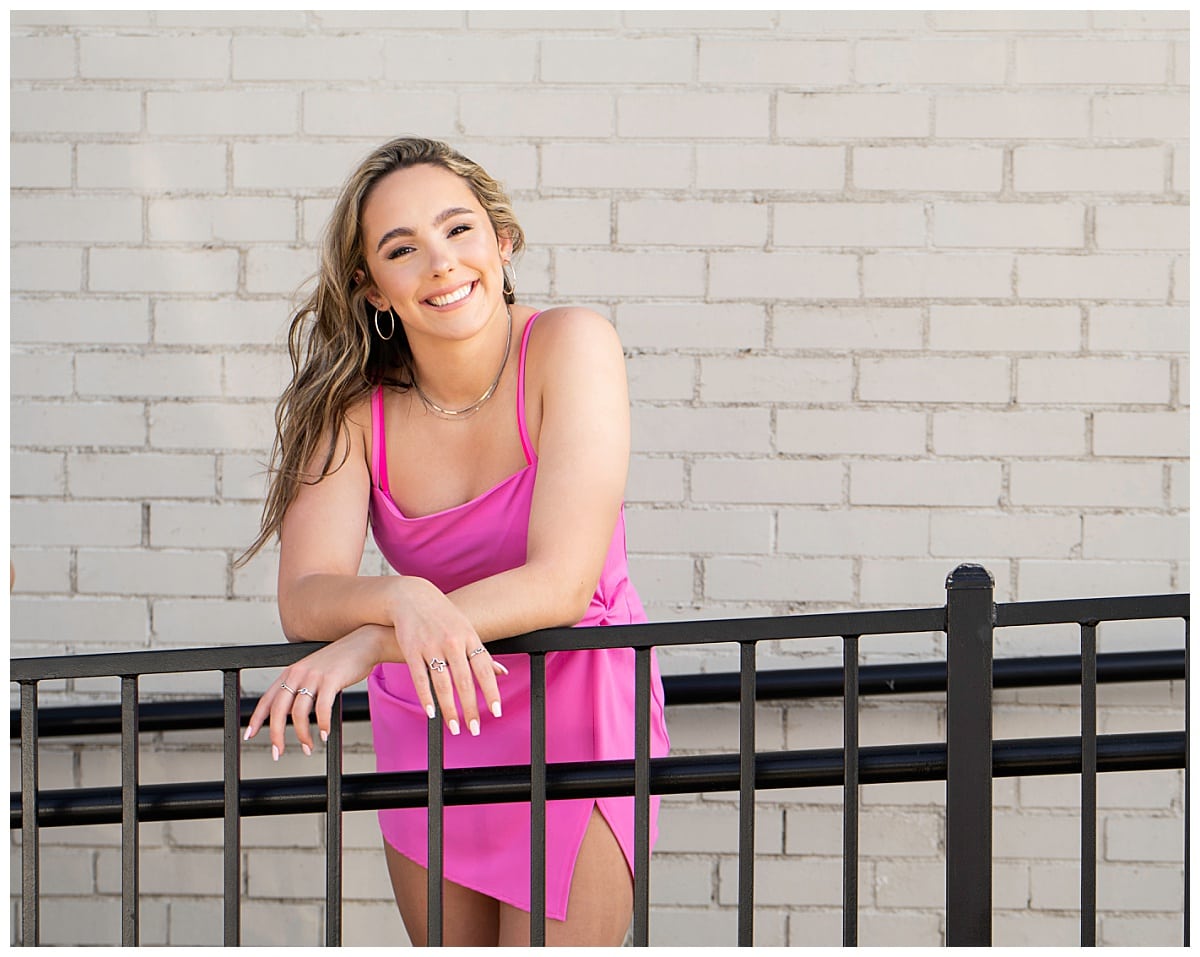 girl in pink dress leans on railing for Downtown Georgetown + Spring Wildflower Session